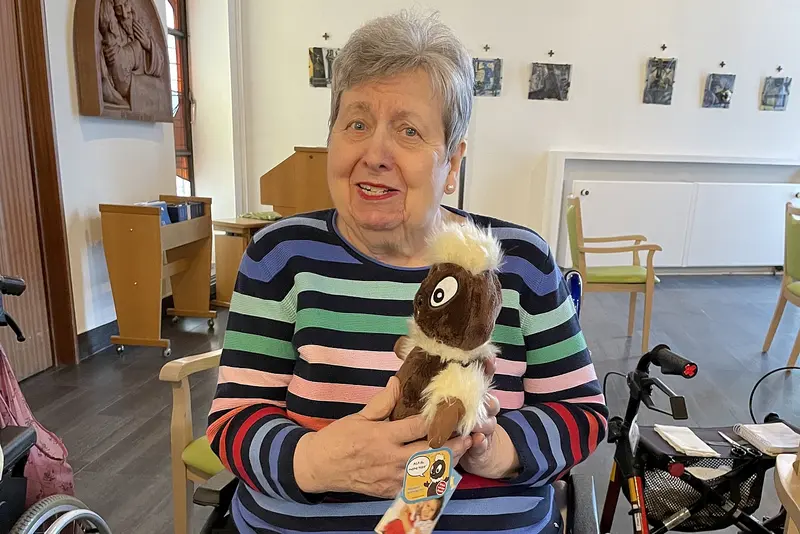 Eine Bewohnerin des St. Vinzenz hält eine Puppe von Pitti Platsch in den Händen.