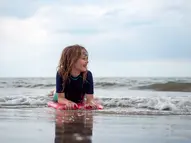 Mädchen spielt im Wasser am Strand