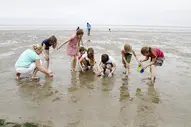 Kinder spielen im seichten Wasser am Strand von Spiekeroog