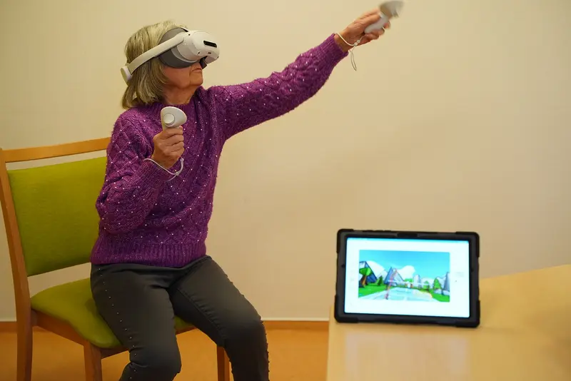Eine Seniorin testet ein Virtual-Reality-Spiel.