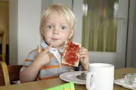 Kleiner Junge lässt sich sein Marmeladen Brot schmecken