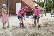 Drei Mädchen spielen auf dem großzügigen Spielplatz der Kurklinik Haus am Deich