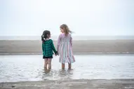 Kinder spielen zusammen am Strand